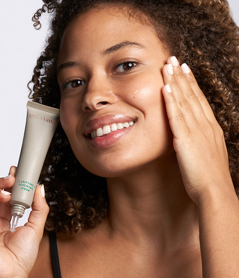 Kvinna som applicerar Clarifying and Renewing Serum på sin kind.