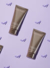 Exuviance produkten exfoliating & conditioning foot balm mot lila bakrund.