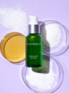Exuviance produkten radiance serum mot en lila bakrund med ingredienser runt omkring.
