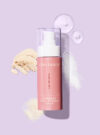 Exuviance produkten advanced total correct serum mot lila bakrund med ingredienser runt omkring.