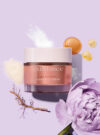 Exuviance produkten rebuild-5 cream mot en lila bakrund med ingredienser runt omkring.