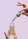 Två händer håller upp produkten citrafirm face oil.