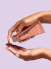 Två händer trycker ut kräm från produkten day repair SPF 30.